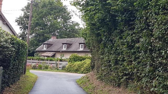 a house on a road next to a hedge at Villa Fiquefleur in Fiquefleur-Équainville