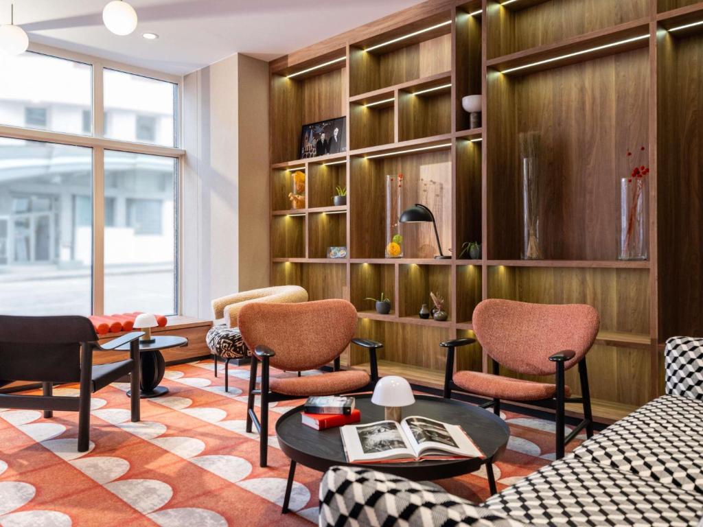 Una sala de estar con sillas, un sofá y una mesa. en Hotel Mercure Wien City, en Viena