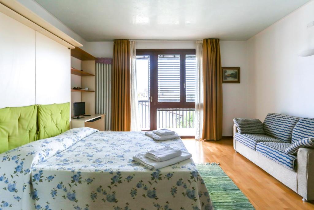 プレガンツィオールにあるLa mini Dimora di Laraのベッドルーム(ベッド1台、ソファ付)
