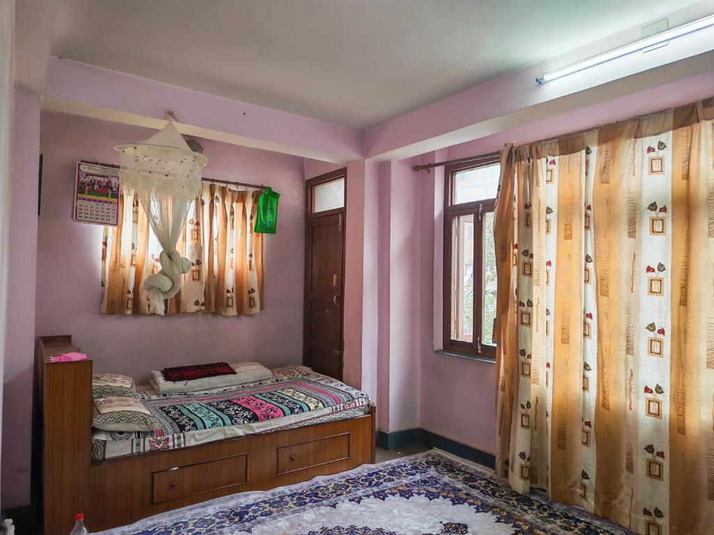 a bedroom with a bed and a window at 'Timeless Bhaktapur Home' in Bhaktapur