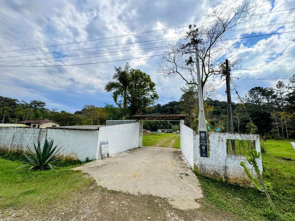 ein Gebäude mit einem Baum neben einer unbefestigten Straße in der Unterkunft Ohana in Peruíbe