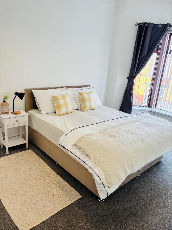 a large bed in a room with a window at Wallasey Nest in Wallasey