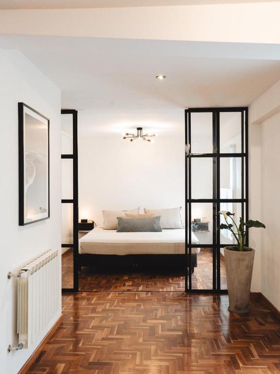 a bedroom with a bed and a wooden floor at Casa Brown in Neuquén