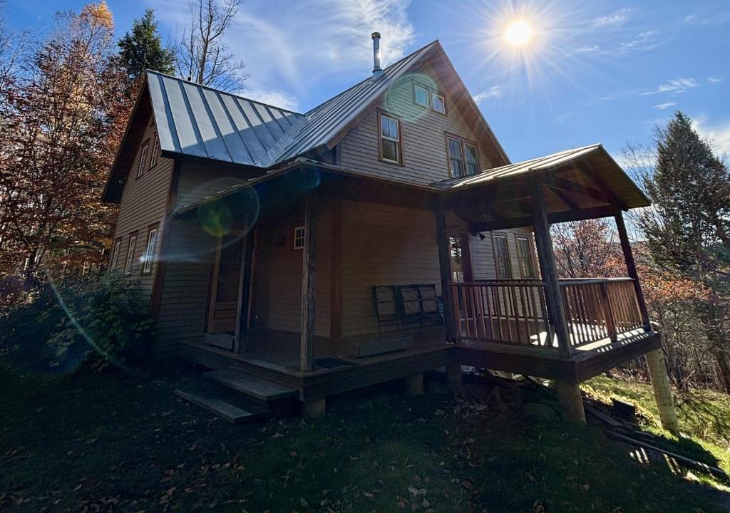 a house with a porch and a solar roof at Light-filled Retreat in Mad River Valley in North Fayston