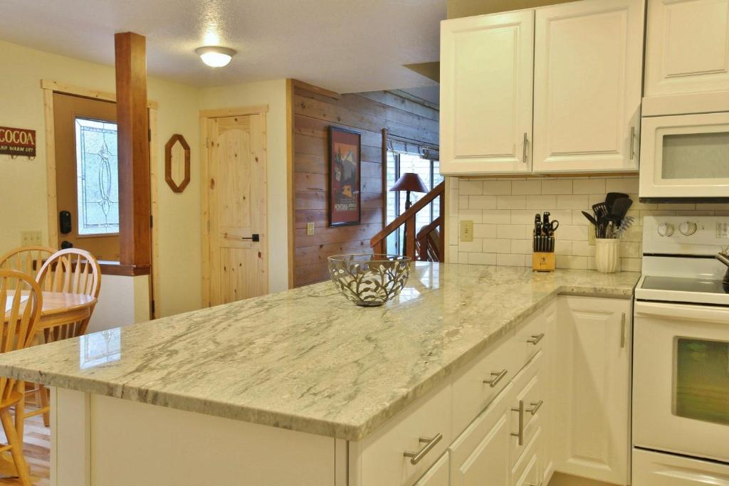 Una cocina con gabinetes blancos y encimera. en 8 Leisure, en Sunriver