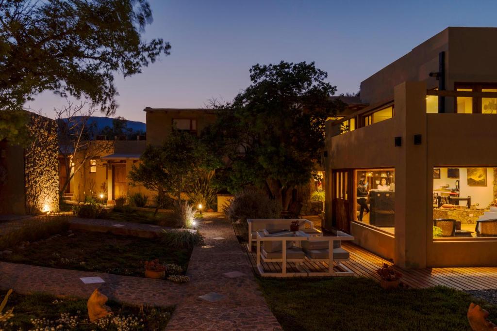 une maison avec terrasse dans la cour la nuit dans l'établissement Al Sereno Hotel Spa, à Tilcara