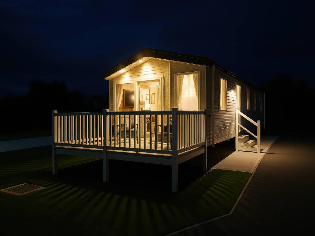 a cabin with a lit up deck at night at Lakeland Leisure Park - Holiday Accommodation 20349 in Flookburgh