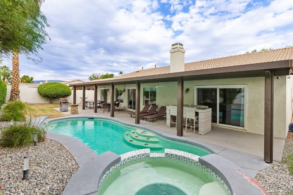 a home with a swimming pool and a house at Navigate Stays Luxe Retreat w Pool Spa & Games in Desert Groves Mobile Home Park