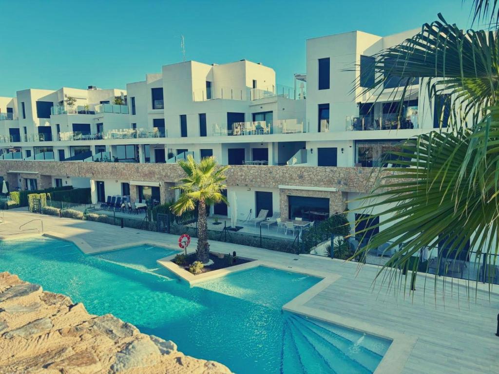 ビジャマルティンにあるSoleil Villamartin Golfの大きな建物で、目の前にスイミングプールがあります。