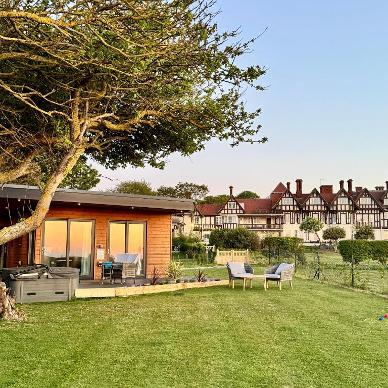 a home with a yard with chairs and a house at Sea Marge Seaview Lodges in Overstrand