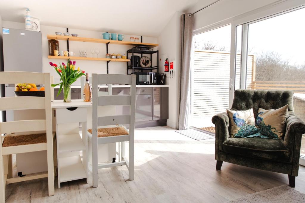 ein Wohnzimmer mit einem Stuhl und einem Tisch in der Unterkunft Willow Cottage in Ryde