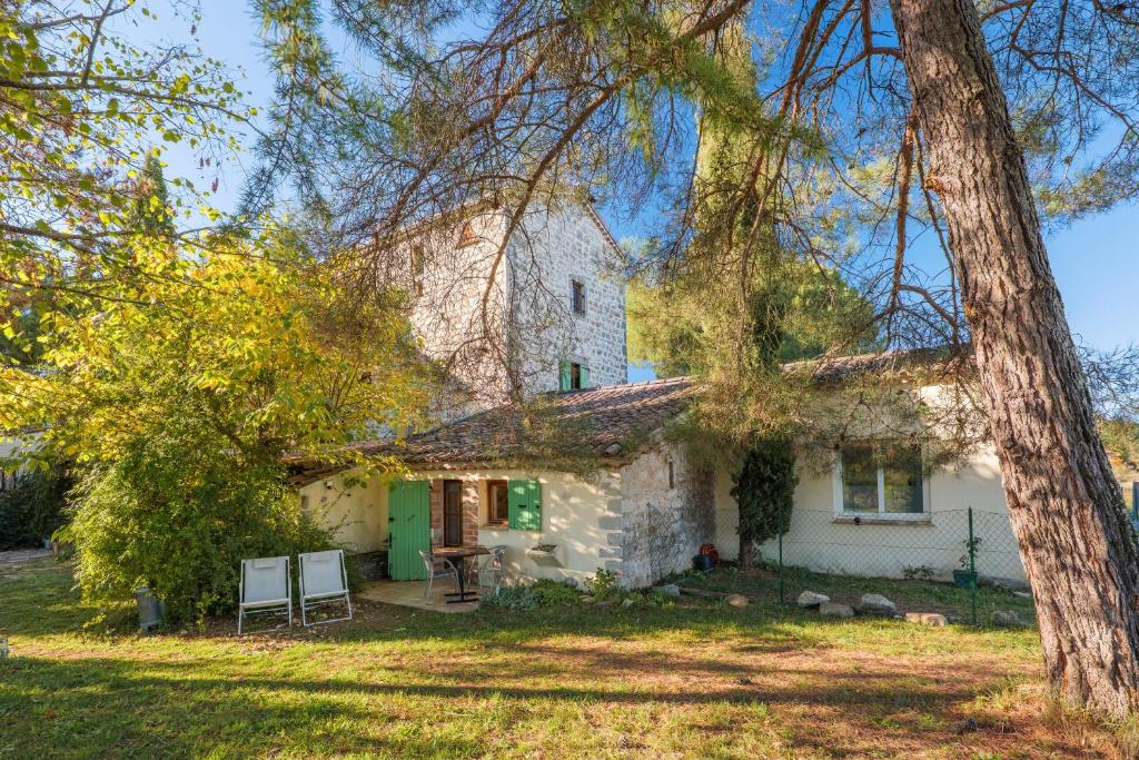 ein altes Steinhaus mit grüner Tür in der Unterkunft Chambre La Louve in Berrias Et Casteljau