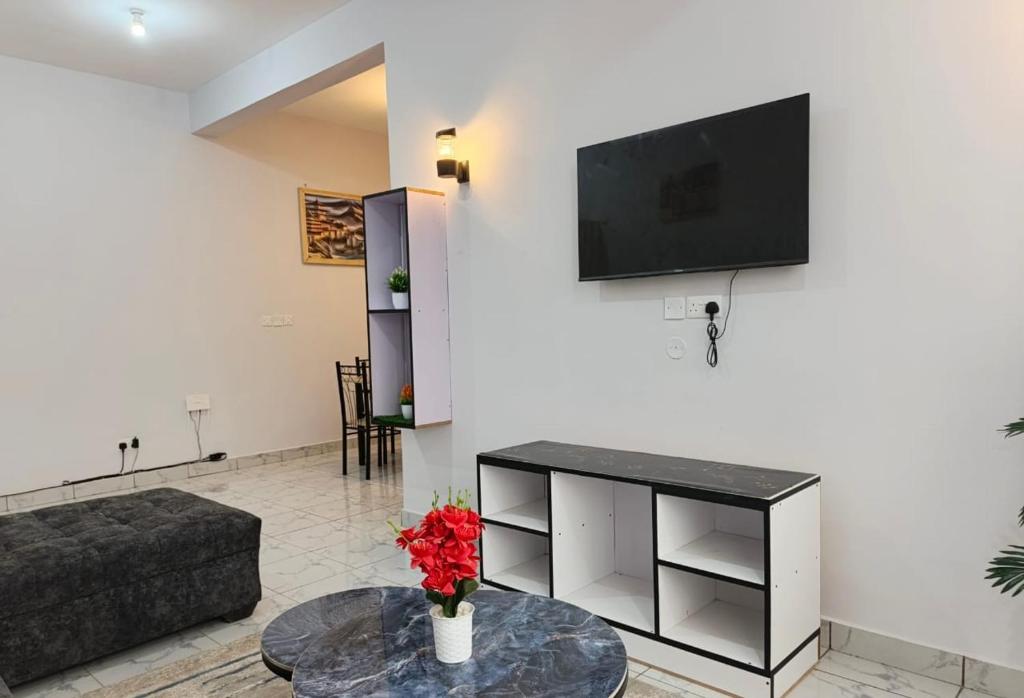 a living room with a couch and a tv on a wall at Blessing homes in Mombasa