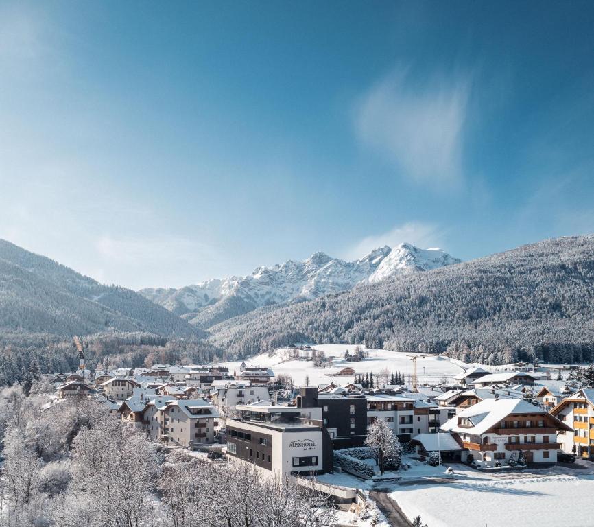 a town in the snow with mountains in the background at Alpinhotel Keil in Valdaora