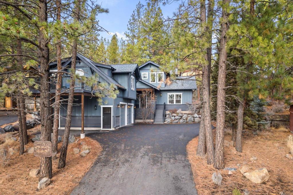 a house in the woods with a driveway at Trails End Retreat in Bend