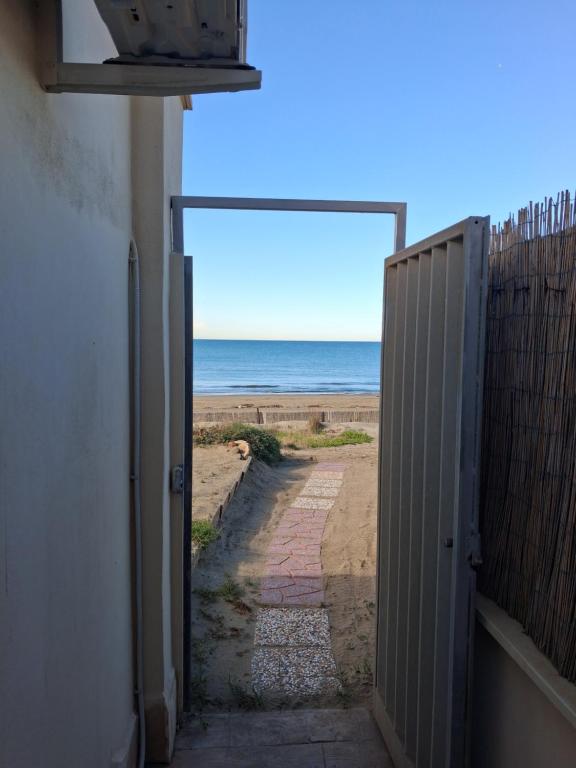 an open door to the beach with the ocean behind it at Casa Roberto Beach in Torvaianica