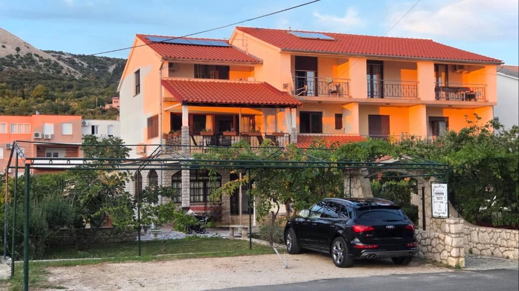 a black car parked in front of a house at Guest House Gordana in Banjol
