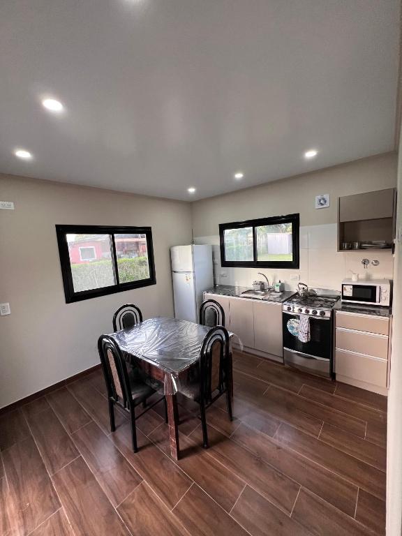 a kitchen with a table and a stove and refrigerator at Hospedaje a 2 cuadras del mar Mar de Cobo 4 personas in Mar de Cobo