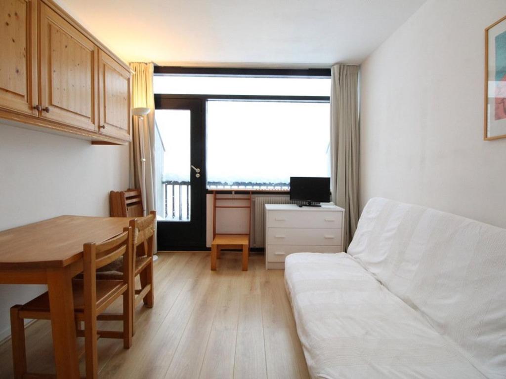 a living room with a table and a white couch at Studio en front de neige à Flaine, idéal pour skieurs, 4 pers, animaux admis - FR-1-687-58 in Arâches-la-Frasse