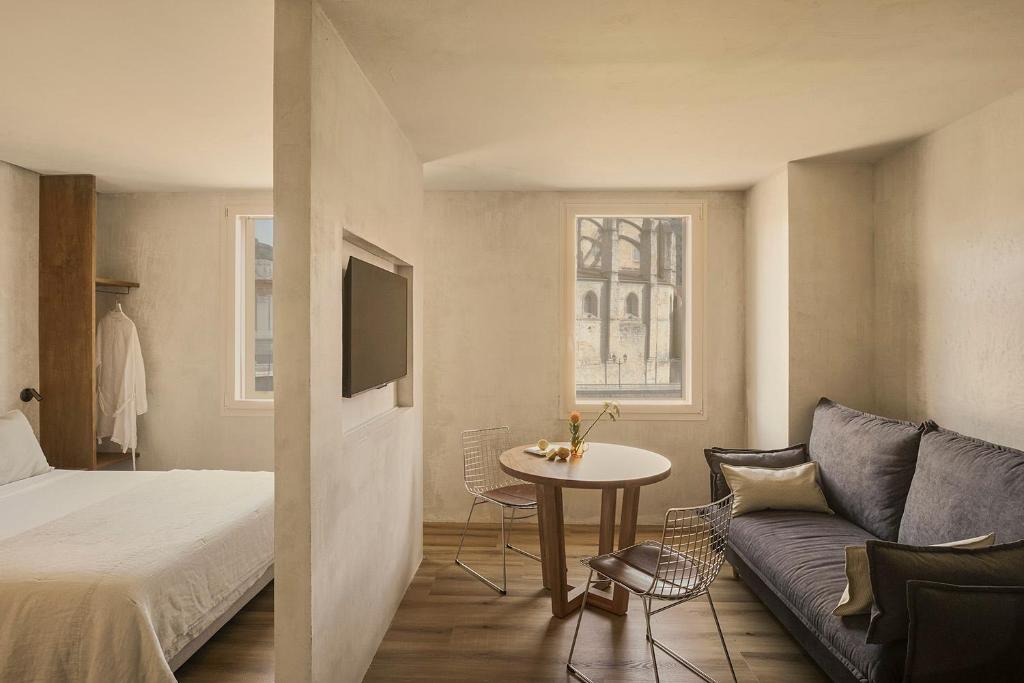 Cette chambre comprend un lit, un canapé et une table. dans l'établissement Enea Living, à Bilbao
