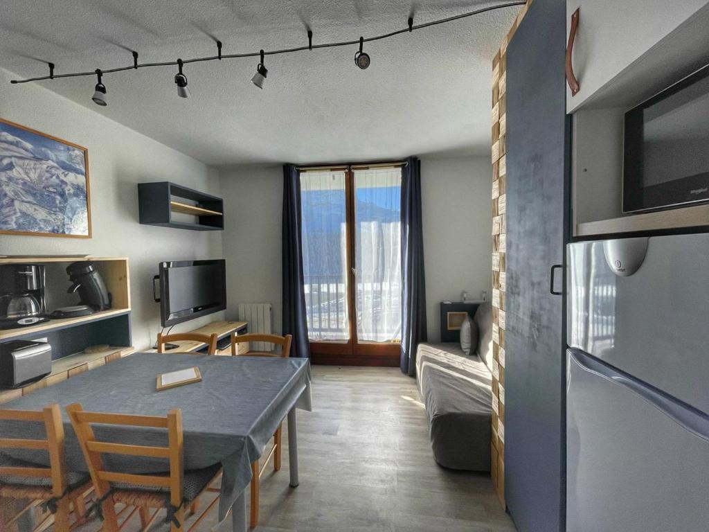 eine Küche und ein Wohnzimmer mit Tisch und Stühlen in der Unterkunft Charmant Studio Cabine avec Coin Montagne pour 5 Pers., Résidence Doris, Proche Pistes et Commerces. - FR-1-687-62 in Arâches-la-Frasse