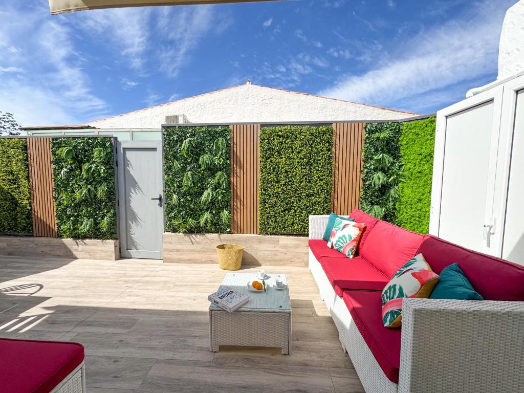 un salon avec un canapé rouge sur une terrasse dans l'établissement Oasis Beach Home II Playa del Inglés, à Playa del Ingles