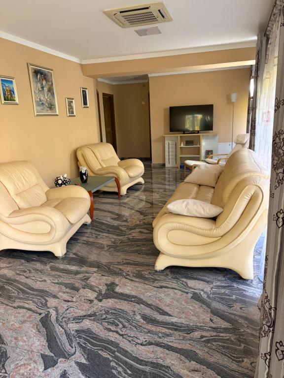 a living room with couches and a tv at Docara Urban Stay in Craiova