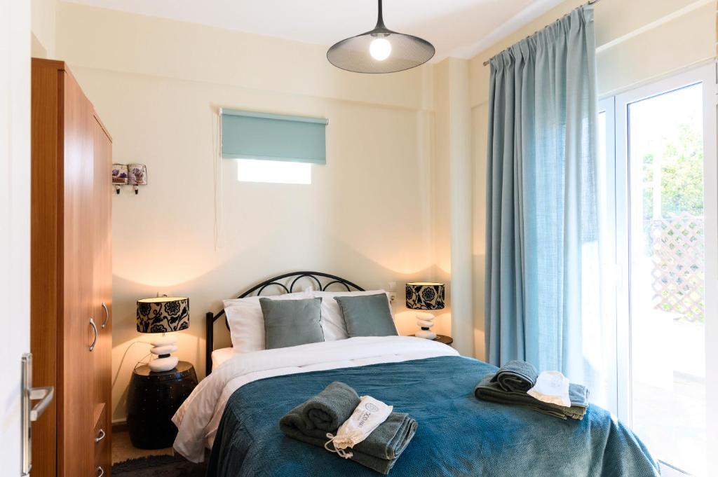 ein Schlafzimmer mit einem Bett mit blauen Laken und einem Fenster in der Unterkunft Seaside House In Agios Vasilios in Áyios Vasílios