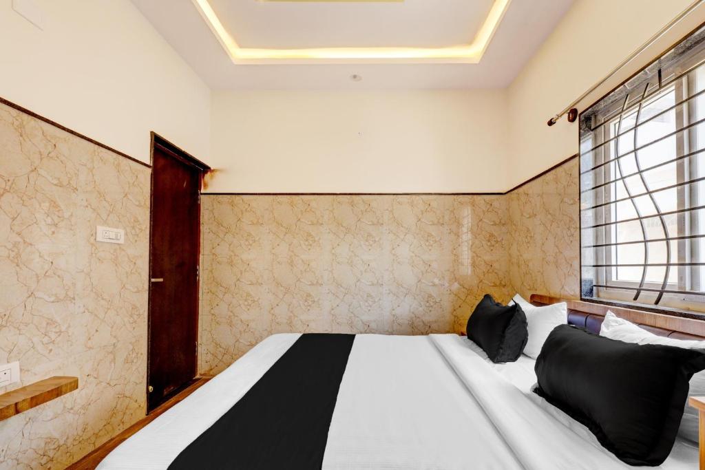 - une chambre avec un lit doté d'oreillers noirs et une fenêtre dans l'établissement Hotel O NG COMFORTS, à Bangalore