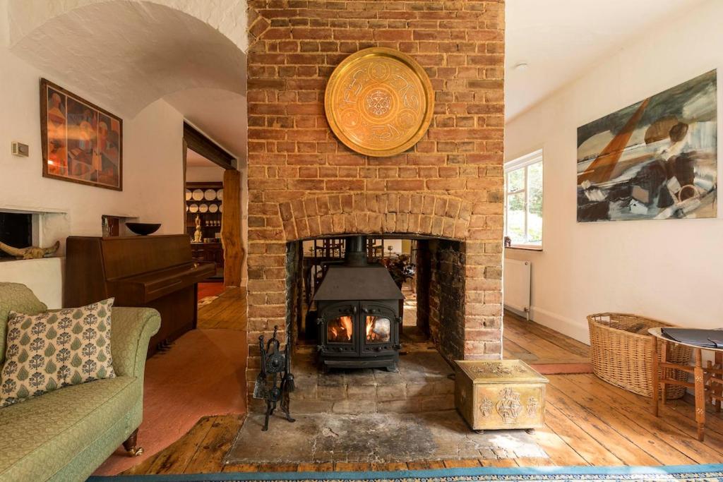a brick fireplace in a living room with a fire place at Large family home based at Westerlands Farm in Graffham