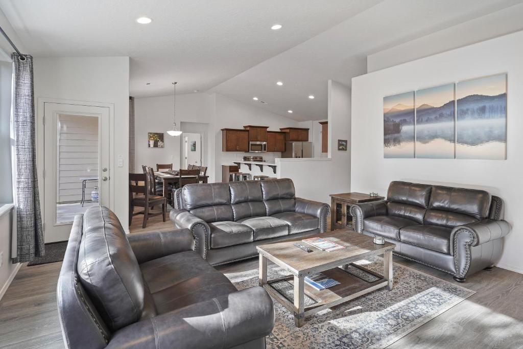 a living room with leather furniture and a table at Four Seasons Retreat in Sunriver