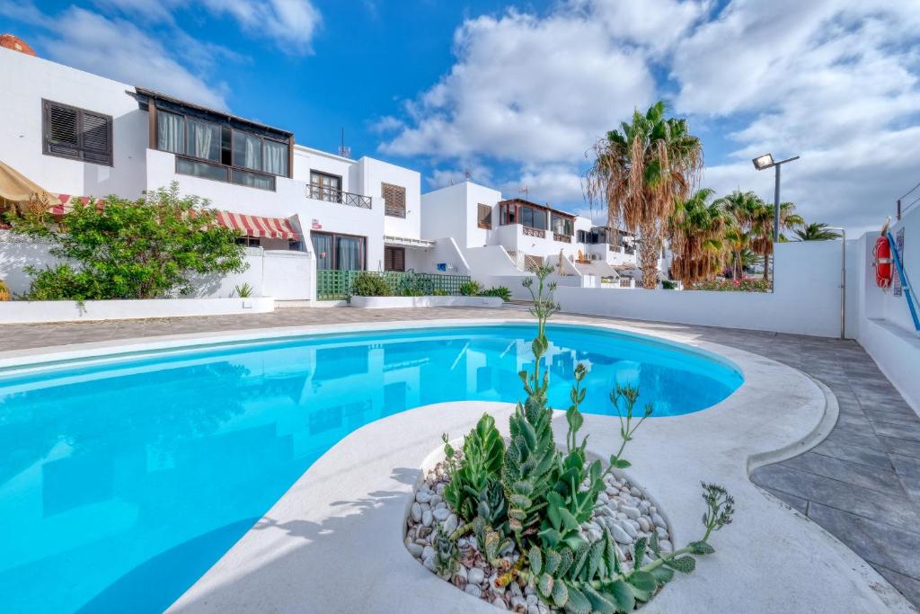 een villa met een zwembad en een huis bij Casa Ondina in Puerto del Carmen