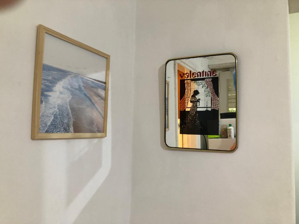 two framed pictures on a wall with a mirror at Departamento Adrián in Mar del Plata