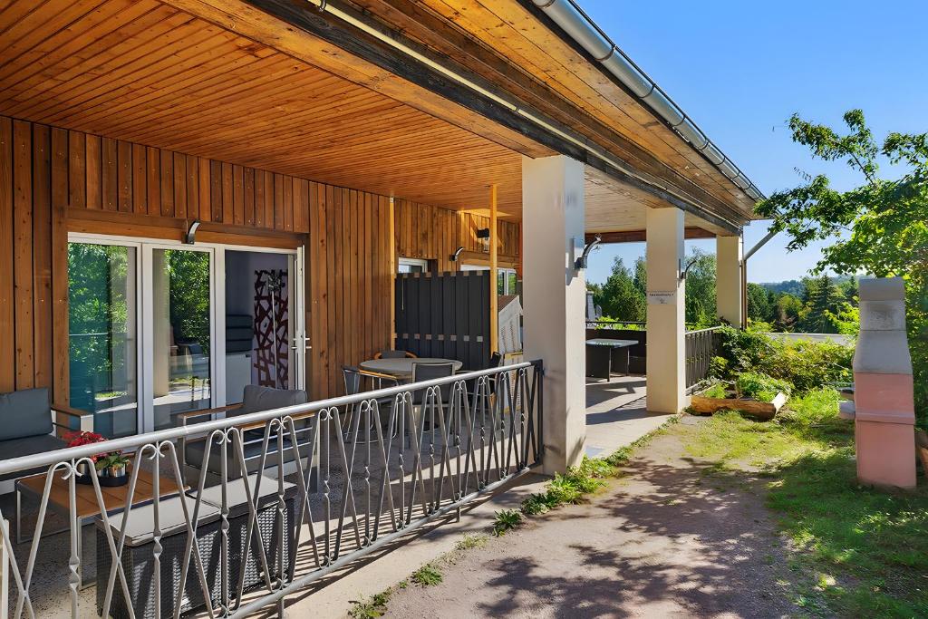 a covered porch of a house with chairs and tables at Ferienwohnung "Zum Segel" 2 in Zadelsdorf