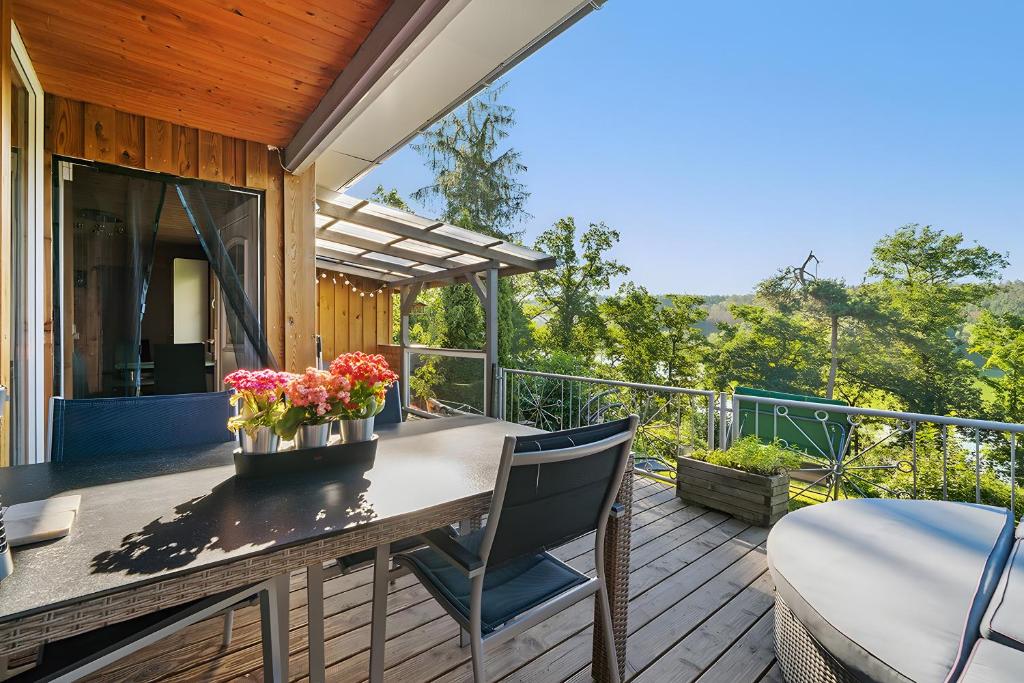 een terras met een tafel en stoelen op een dek bij Ferienhaus 249 - Haus Seeblick in Kleinwolschendorf
