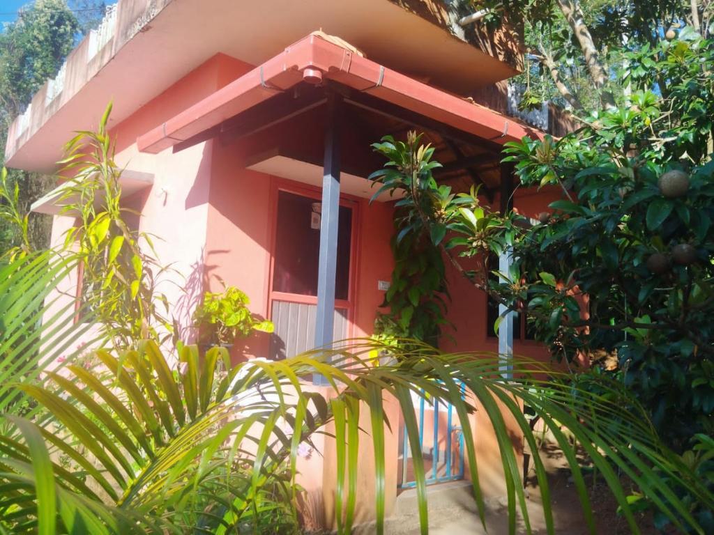 a red house with a white door and trees at Wood stone step in Napoklu