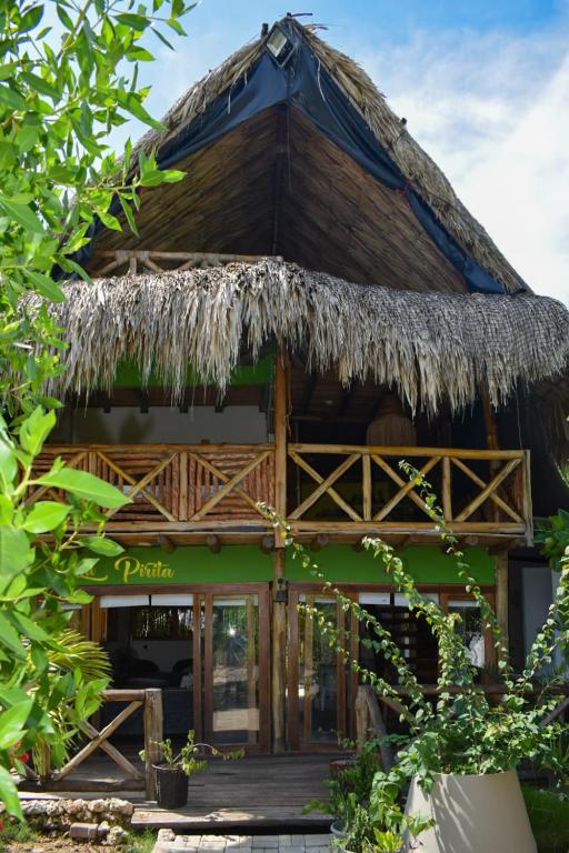 a resort building with a thatched roof at Pirita Beach House in Santa Ana