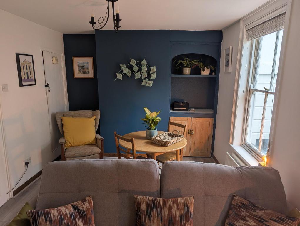 a living room with a couch and a table at Harbour Street Nook in Whitstable