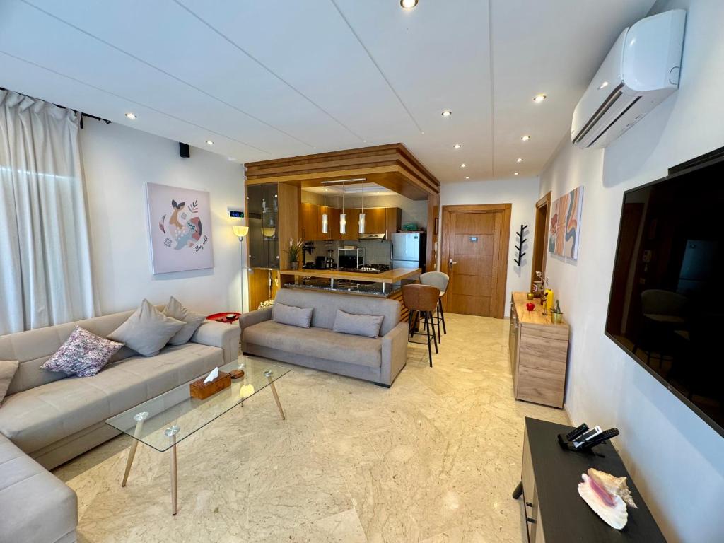 达布阿扎Peninsula Dar Bouazza Superbe appartement en résidence avec piscine activités的带沙发和桌子的客厅