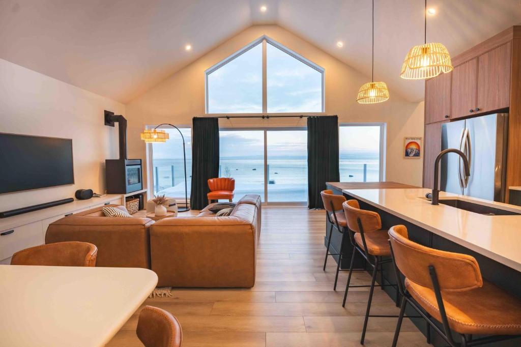 a living room with a couch and a table at Phil Good 1219: Luxurious River View in Charlevoix in Petite-Rivière-Saint-François