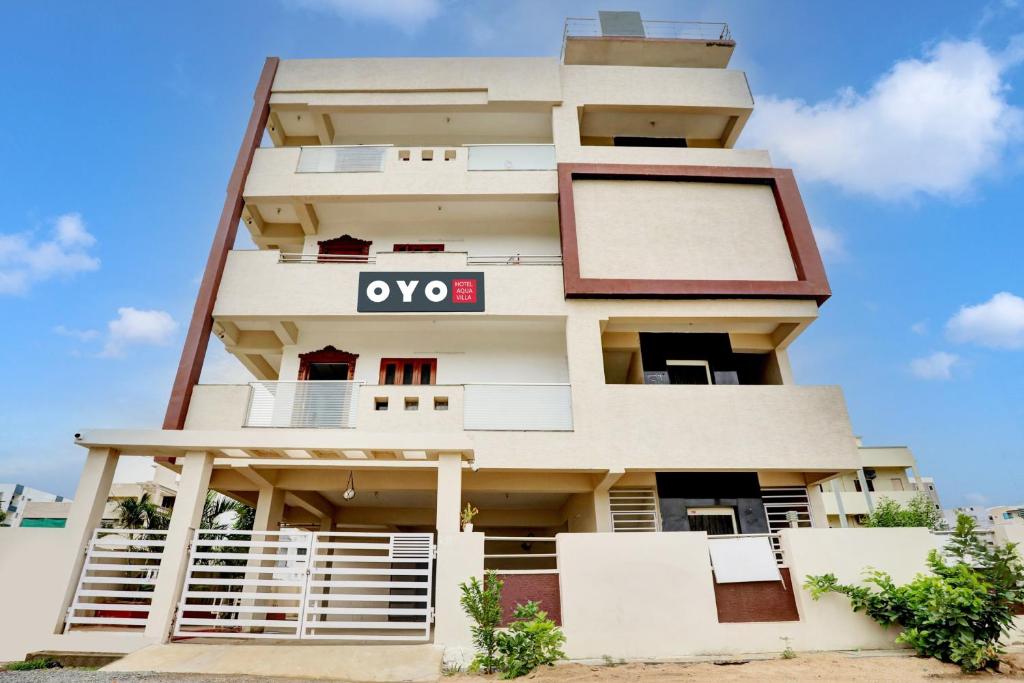 un immeuble d'appartements avec un panneau sur celui-ci dans l'établissement Super Hotel O J3 LUXURY ROOMS, à Guntūr