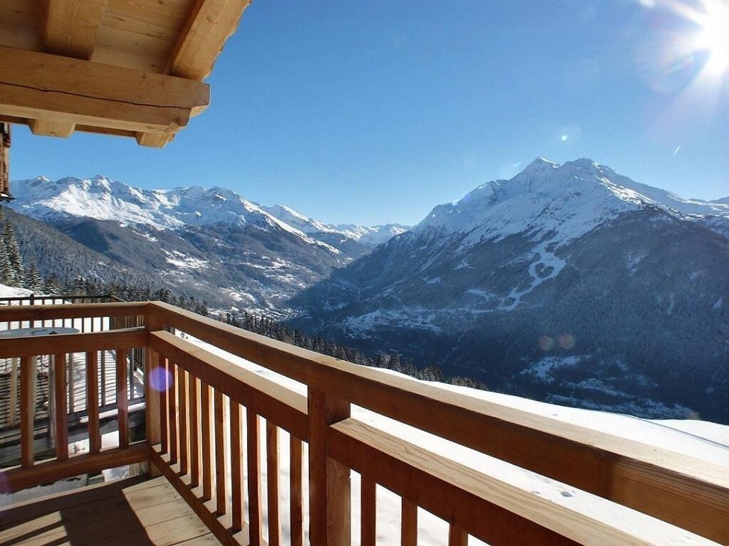 een balkon met uitzicht op een met sneeuw bedekte berg bij Les Alpages du Soleil in La Rosière