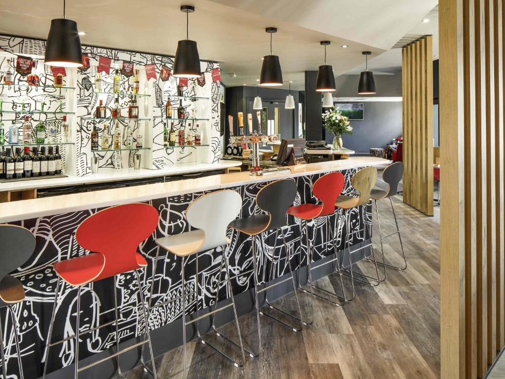 a bar with red and white stools at ibis Coventry Centre in Coventry