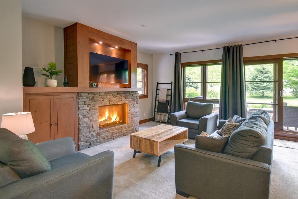 モントランブランにあるTremblant Prestige - Étoile 1510-23の2つのソファと暖炉のあるリビングルーム