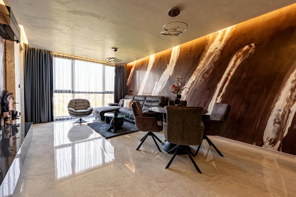 a living room with a table and chairs at Beni Deluxe in Plovdiv