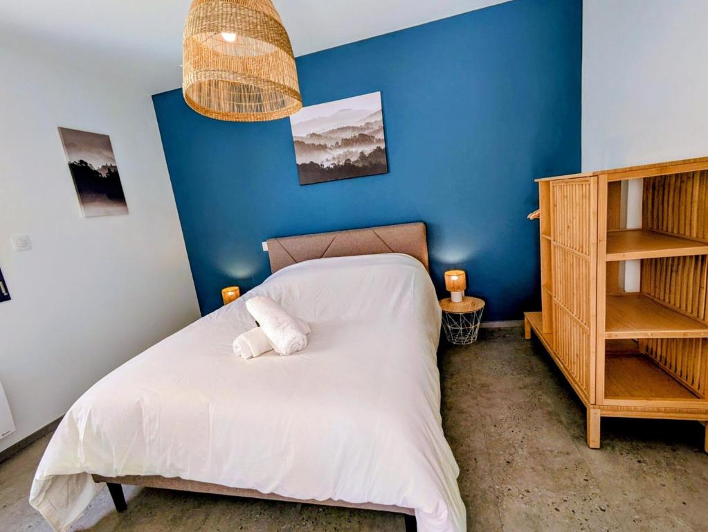 a bedroom with a bed with a blue wall at La maison du petit large in La Bernerie-en-Retz