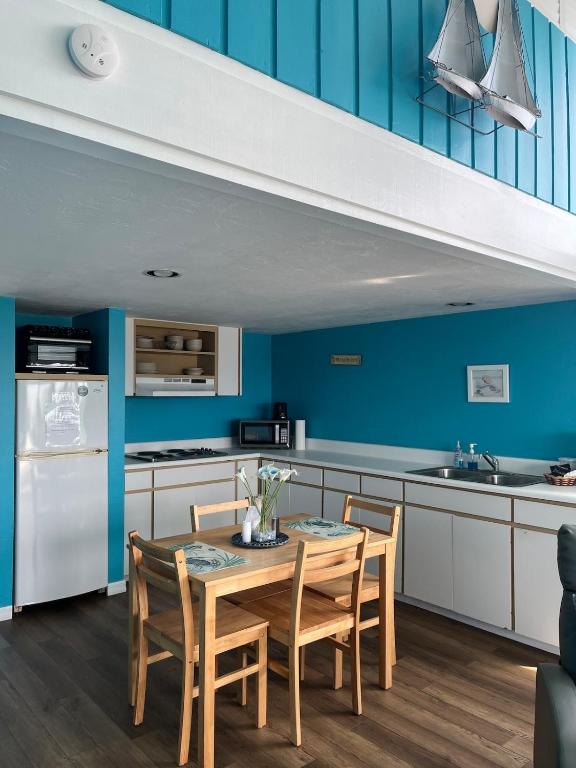 a kitchen with blue walls and a table and chairs at Sky Blue 321 in Cedar Key
