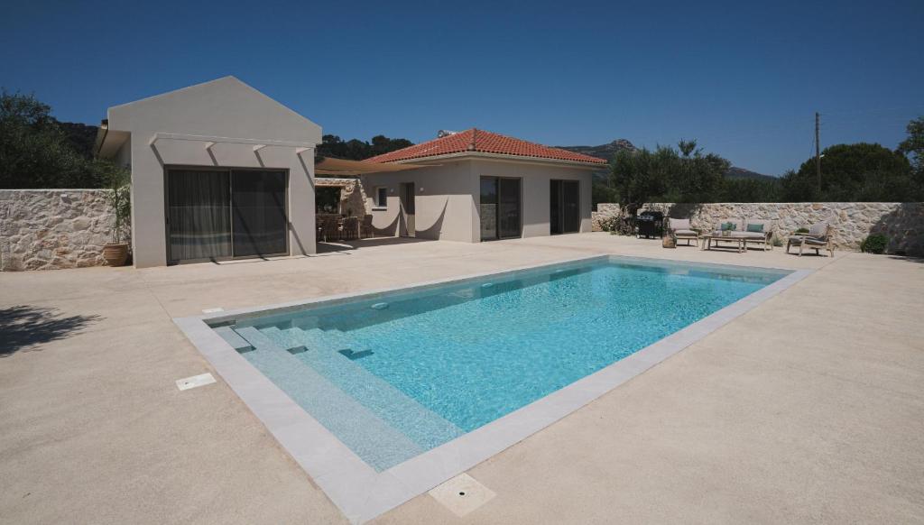 a swimming pool in front of a house at Alkinari Villa, by TK Premium Stays in Vasilikos