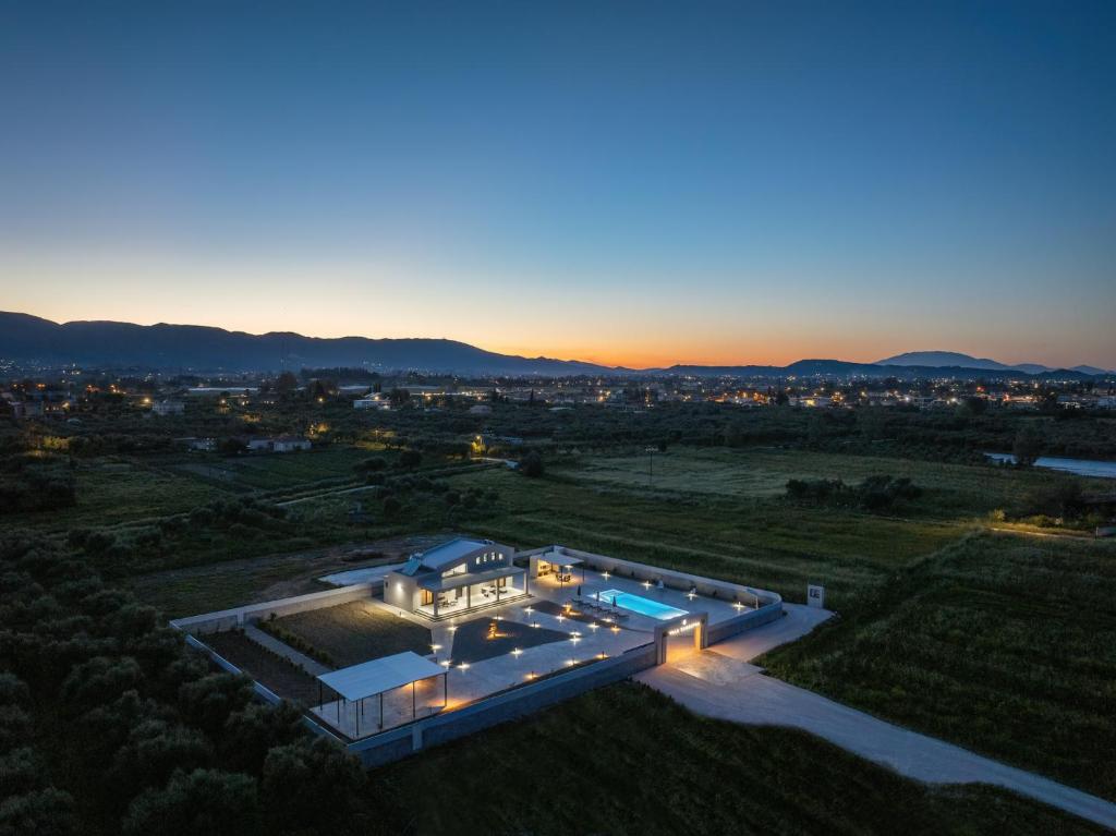 an aerial view of a house at dusk at Villa Samantha - Private Pool, 3 Ensuite Bedrooms & Complete Privacy near Laganas, By TK Premium Stays in Ambelókipoi