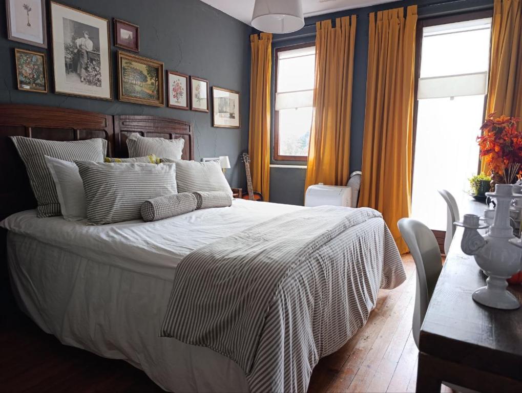 une chambre avec un lit, une table et des fenêtres dans l'établissement Brockwood Manor Tea House - Valdilana, à Valle Mosso